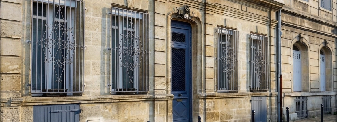 Façade d'échoppe bordelaise en pierre de taille avec porte bleue et grilles forgées - Bordeaux