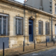 Façade d'échoppe bordelaise en pierre de taille avec porte bleue et grilles forgées - Bordeaux