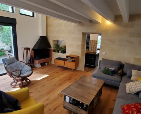 rénovation partielle à Bordeaux Bastide salon avec poutres apparentes parquet neuf et baie vitrée